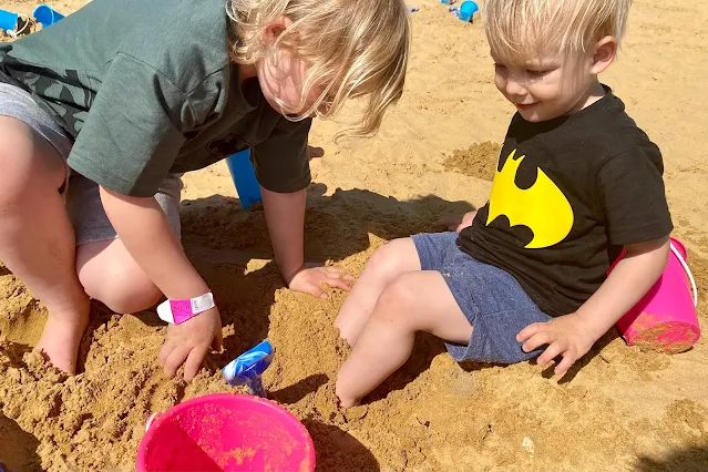 Children digging in the giant sand pit at Marsh Farm with provided buckets and spades