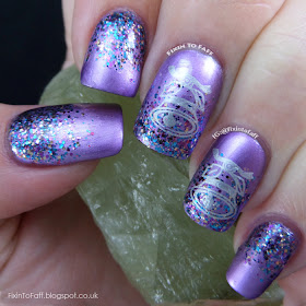 Metallic purple nails with a glitter gradient, topped with stamped silver bells.