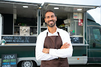 Chef posing for a picture in front of his food truck