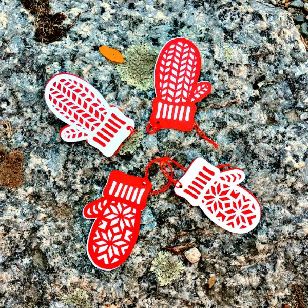 four red and white paper cut mitten gift tags