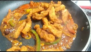 stir frying fried chicken with sauces and vegetables for dragon chicken