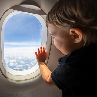 Toddler on an airplane looking out the window