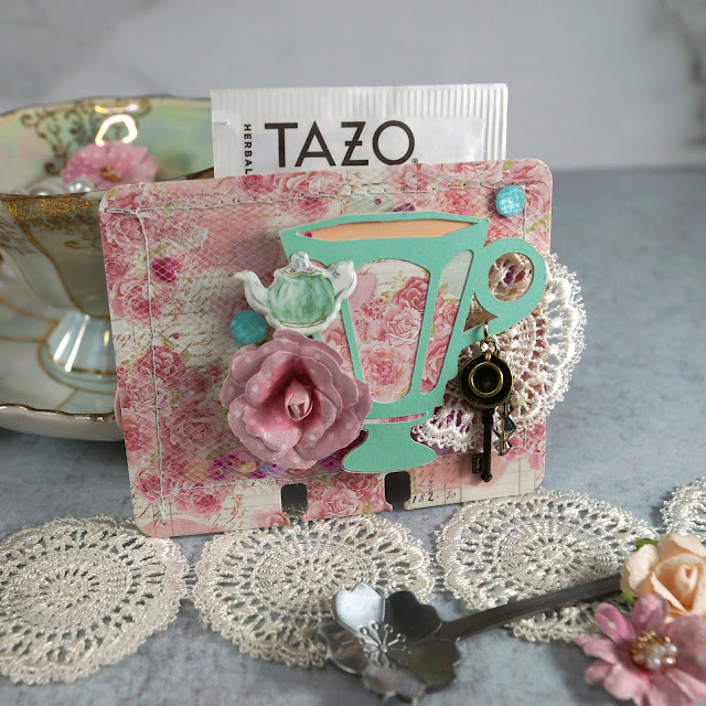 Heidi Swapp Memorydex Valentine's advent calendar made with the Prima With Love collection by Frank Garcia; vintage teacup die cut with a pocket of tea; decorated with ephemera, puffy stickers, paper flowers, lace trim and charms