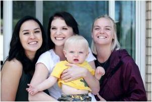 Three women taking care of a baby boy