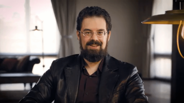 1/2 Handsome Bearded Author Wearing glasses, deep red dress shirt and soft black leather blazer