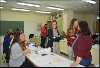 La formadora del taller enseña a los trabajos que van a realizar a la representación municipal que ha visitado las instalaciones