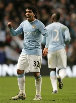 Carlos Tevez reacts to Gary Neville after scoring a penalty