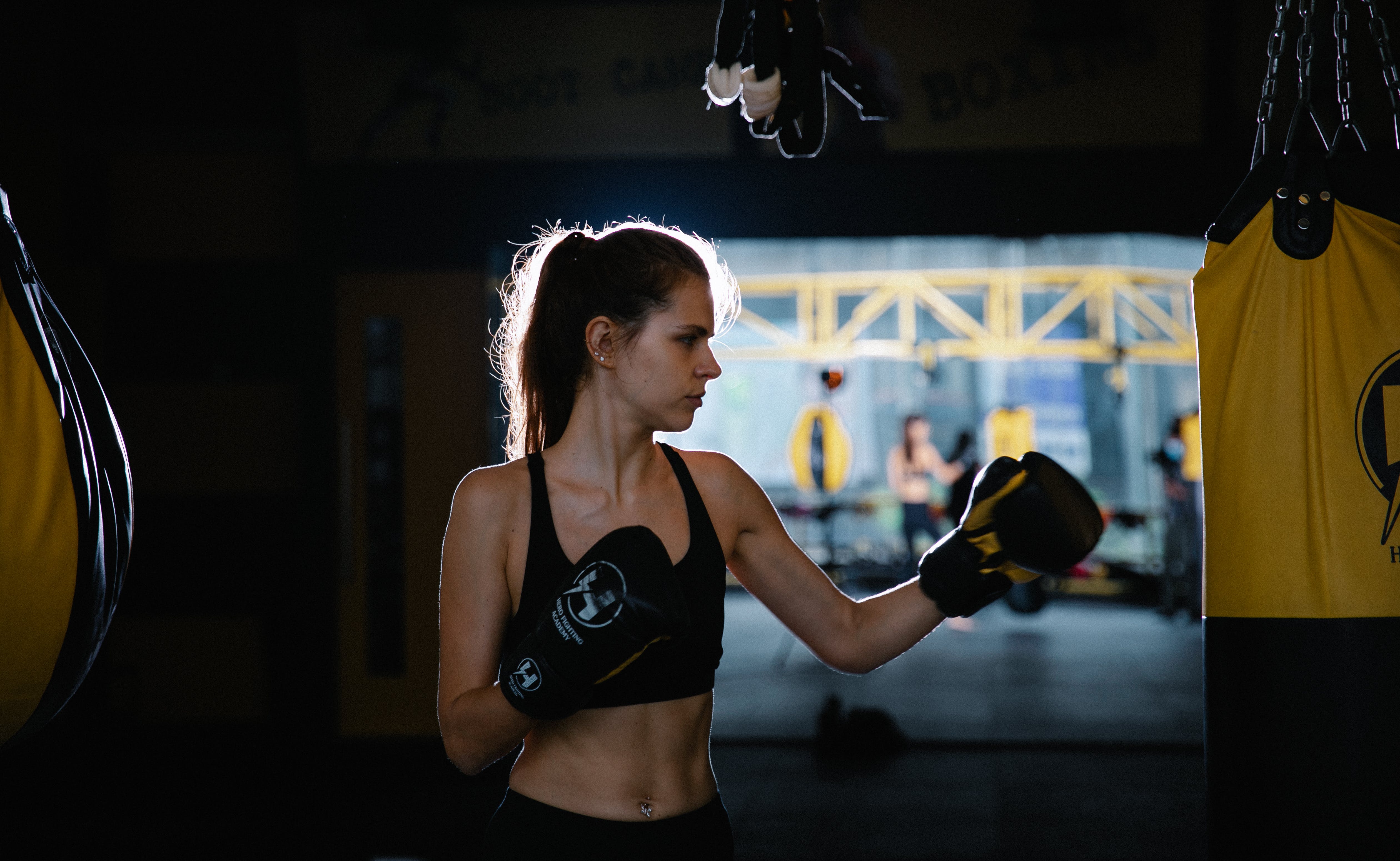 Concentrated fir sportswoman practicing boxing punches in gym