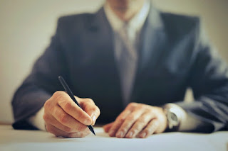 Smartly dressed man writing a note