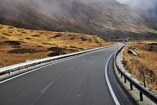 windy road on bridge leading through a mountainside symbolising the difficulty of discerning the truth