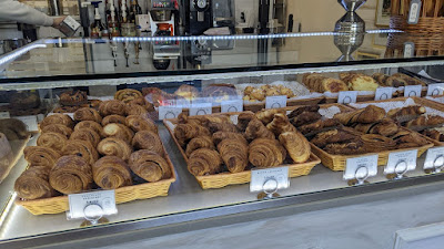 Pastries and croissants offered in glass case at La Paris Brest Cafe.