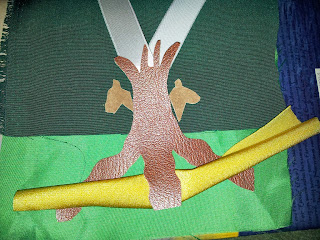Late colour testing including the cut out tree in a redder fake leather, the deer in a fake leather suede that is paler and more yellowy and the yellowy green of the snake to be, plus the white of the ribbon for the Y