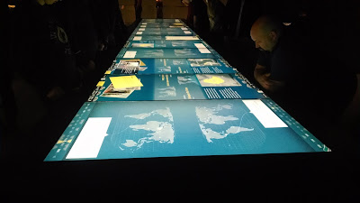 A bank of touchscreen tables with world maps and rights violations