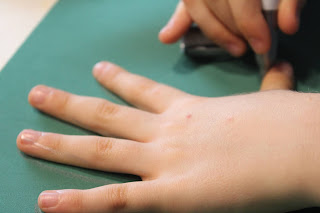 Criança a fazer o contorno da mão em folha eva