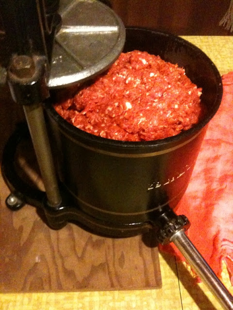 An old sausage press full of ground pork