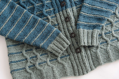 Detail of hand knit cardigan showing cable pattern