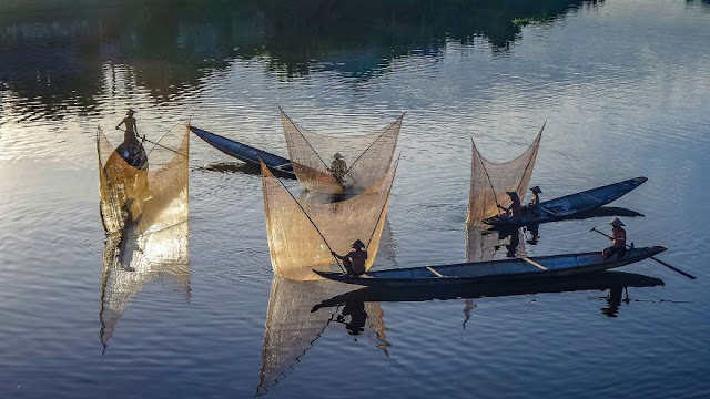 Ngư dân kéo lưới trên sông Hương - Ảnh: Teberik kölgeli
