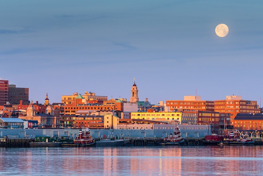 Portland, Maine USA December 2015 photo by Corey Templeton. An almost-full moon setting behind the Portland skyline this morning. Viewed from Bug Light Park in South Portland.