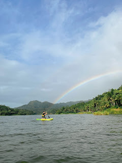 mendayung paddling SUP untuk mendekati pelangi di tengah danau