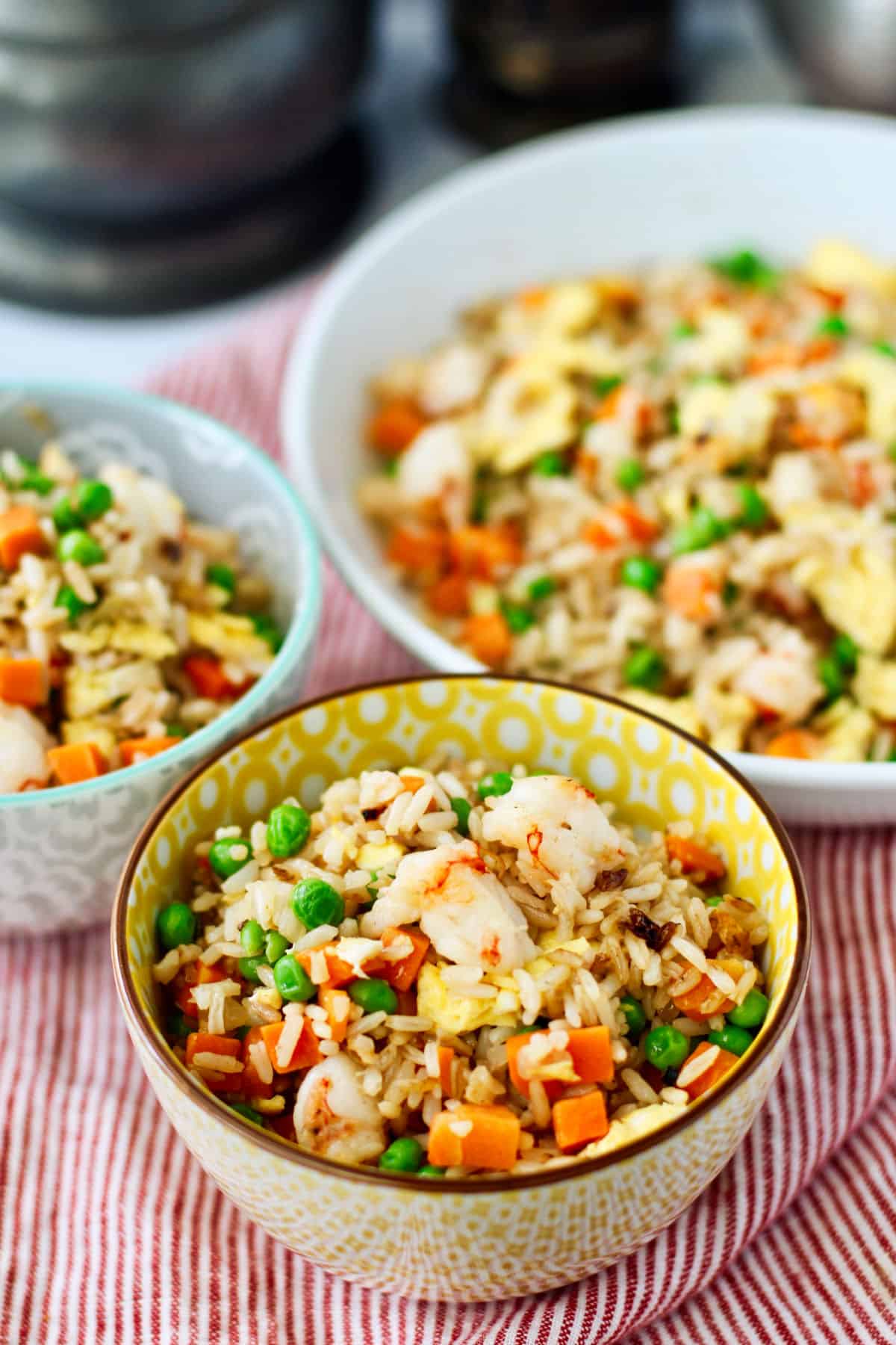 Quick Shrimp Fried Rice with Peas and Carrots in different colored bowls.
