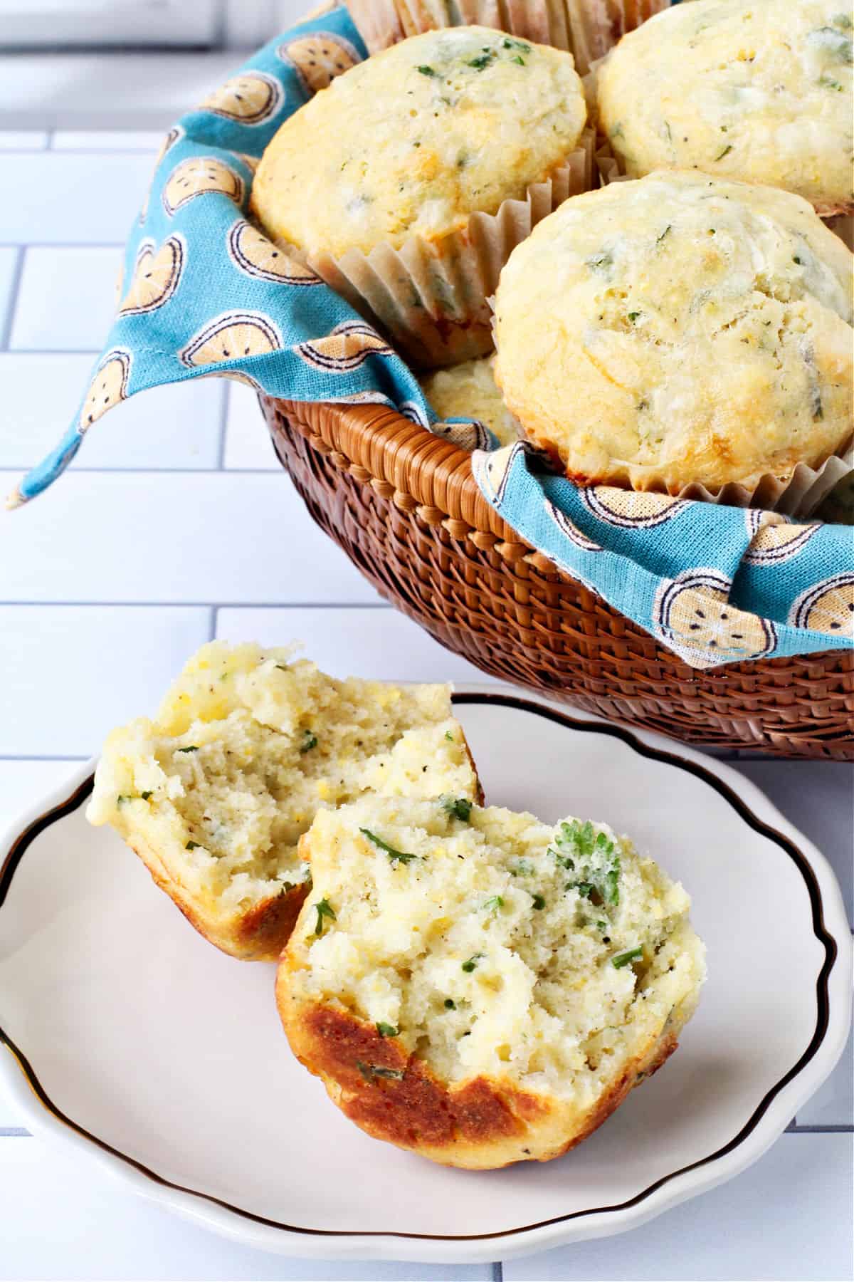 Buttermilk, Herb, and Fontina Cheese Muffin on a plate and cut open to show the crumb.