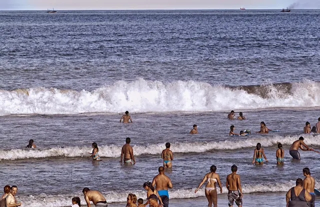 Gente baniándose con olas en el Mar