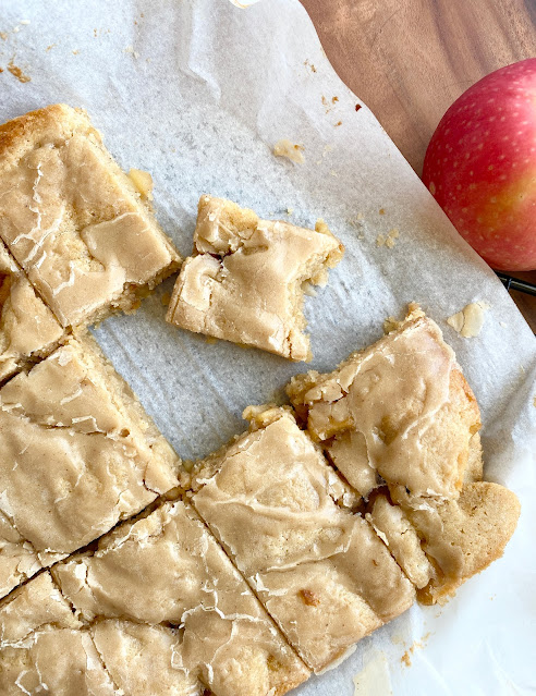 Maple Apple Blondies cut into bars on a sheet of parchment paper.