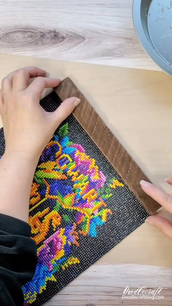 Press the wood down into the glue until the glue cools, ensuring a tight adhesion.   Then repeat the same process for the bottom edge of the diamond art painting.