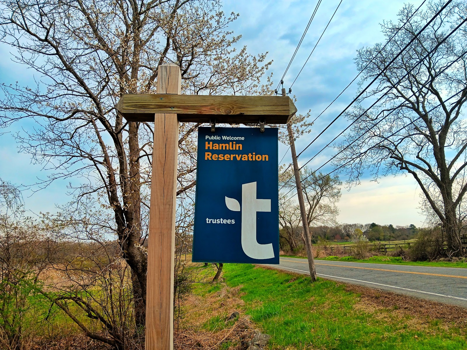 Hamlin Reservation Official Sign A dark blue sign with a white t logo for the Trustees and the words Hamlin Reservation in golden yellow