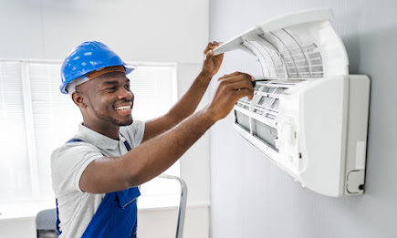 Happy young male technician repairing air conditioner