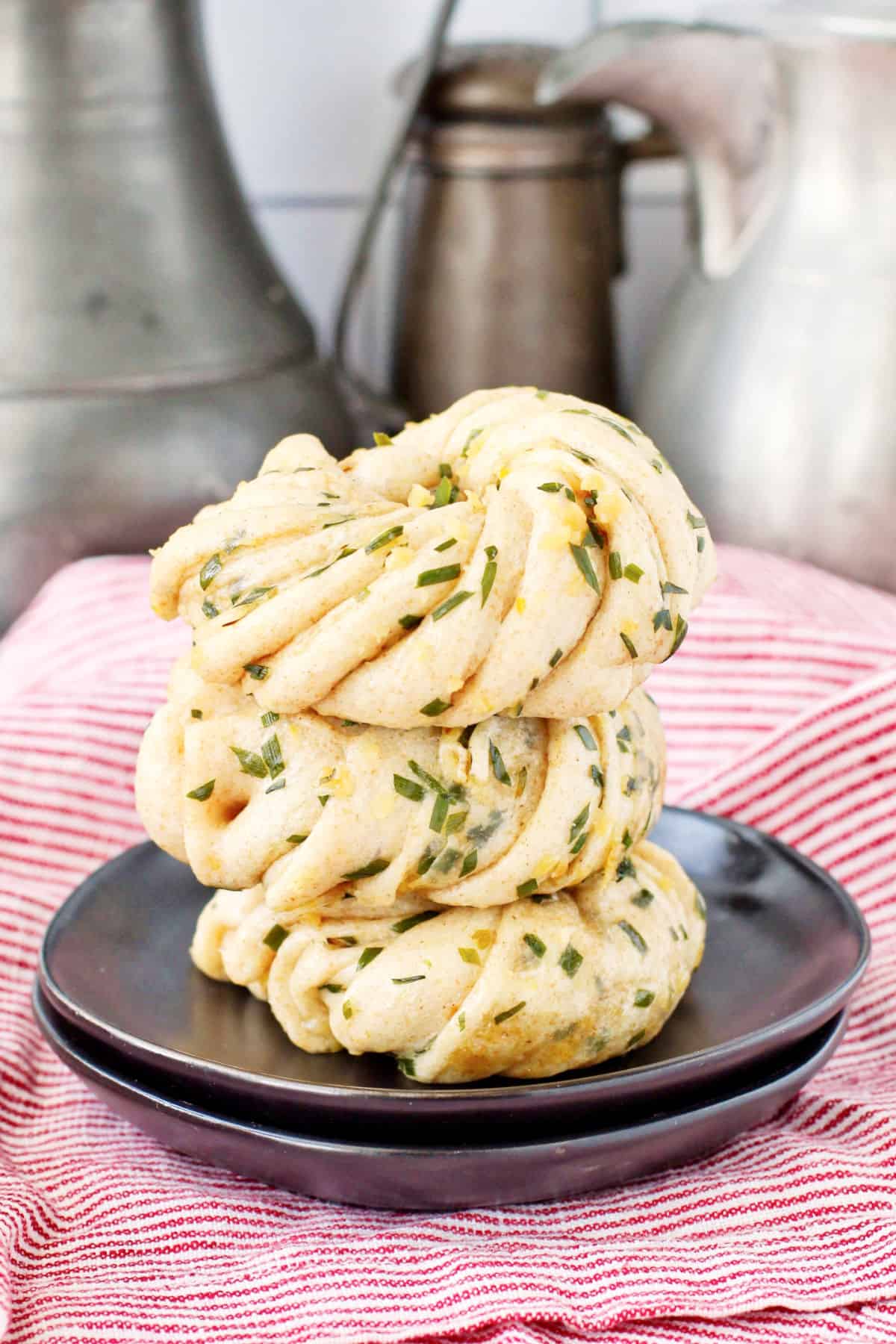 Garlic and Chive Flower Buns stacked on a plate.