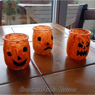 Décoration d'Halloween de photophores citrouille peints sur pot de yaourt en verre