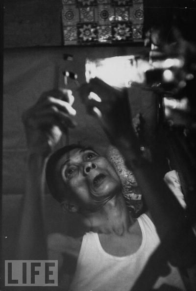 A man prepares to smoke in Laos in 1961.jpg