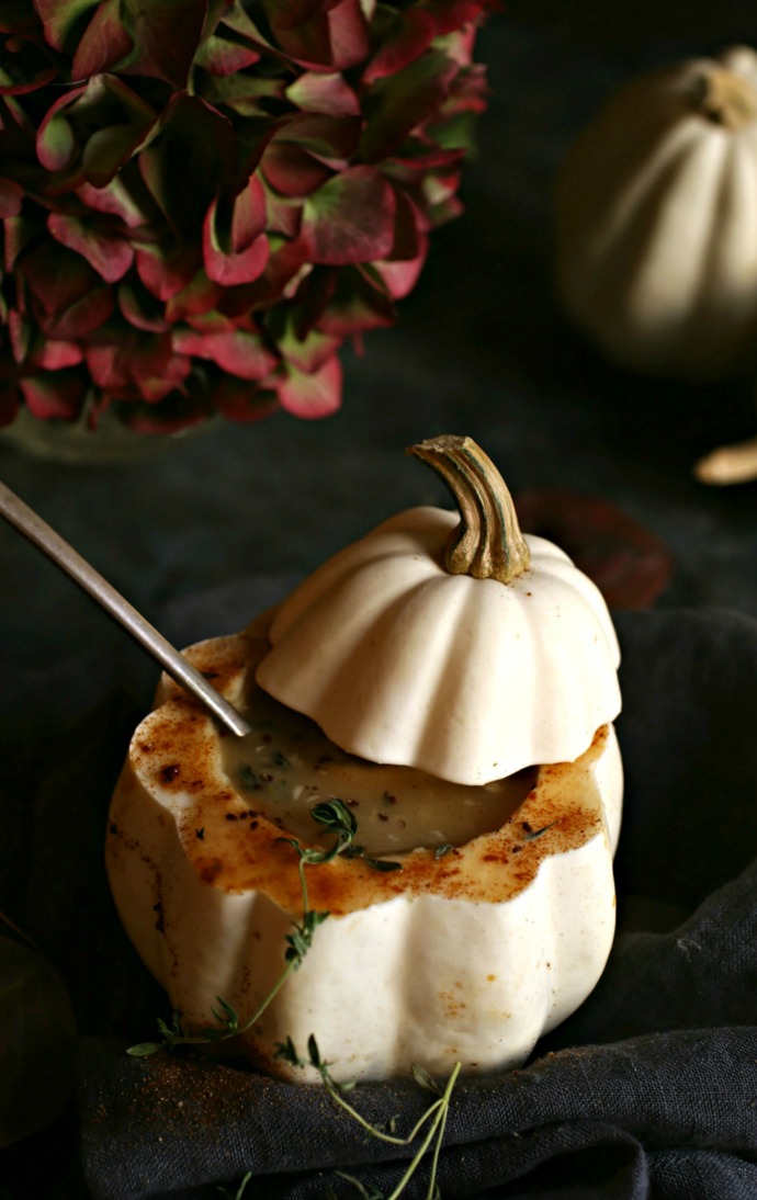 Recipe for a creamy acorn squash and potato soup, flavored with cumin and fresh thyme.