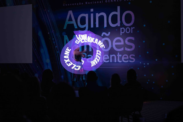 Show de abertura moderno que inclui logomarca projetada com luzes durante a apresentação.