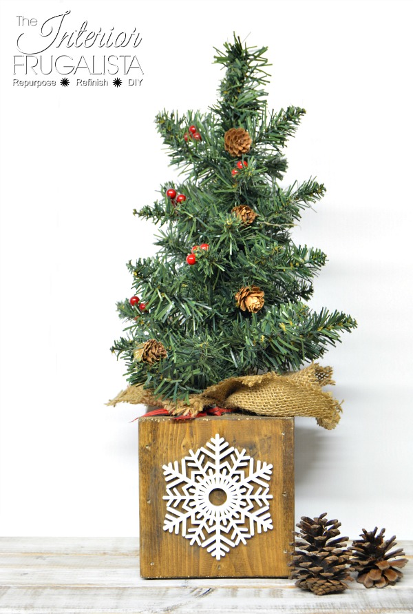 Rustic Christmas centerpiece box with wooden snowflake style four used as a tabletop tree holder.