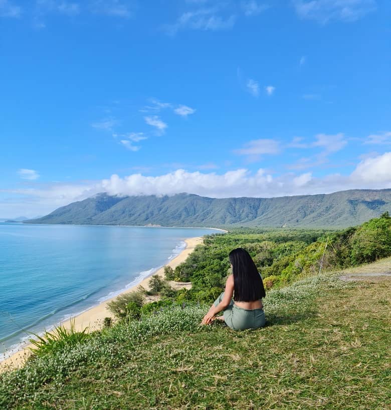 a picture of a woman on the top of the hill, overlooking the coastline