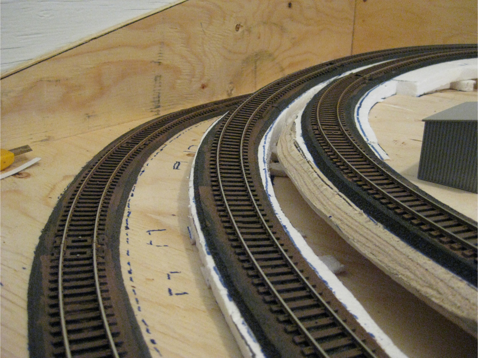 Three curved tracks with their ties painted with brown acrylic paint