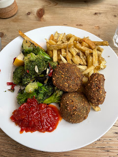 A full plate of food, with fries, broccoli, falafel, and chilli jam.