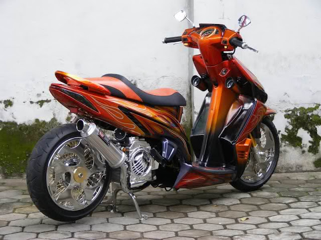 Foto Modifikasi keren Honda Vario Techno bermodif  minimalis gliter orange mengcustom jok untuk menyamakan sesuai dengan pewarnaan cat pada motor jok nya dibuat merundak ala motor GP style knalpot diubah dengan knalpot racing.