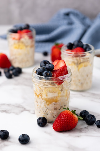 oats in a jar with strawberry and blueberry garnish.
