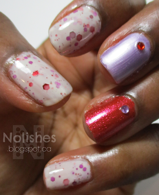 Manicure with a white crelly polish with suspended red and purple glitters, and a red and a purple accent nail with red and purple nail art jewels. Polishes used: KB Shimmer 'Falling for Hue', ILNP 'Love me Not', and China Glaze 'Ah Ah Ah-Mazing!'