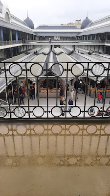 um piso molhado com um grade e vista para a parte interna do mercado do Bolhão