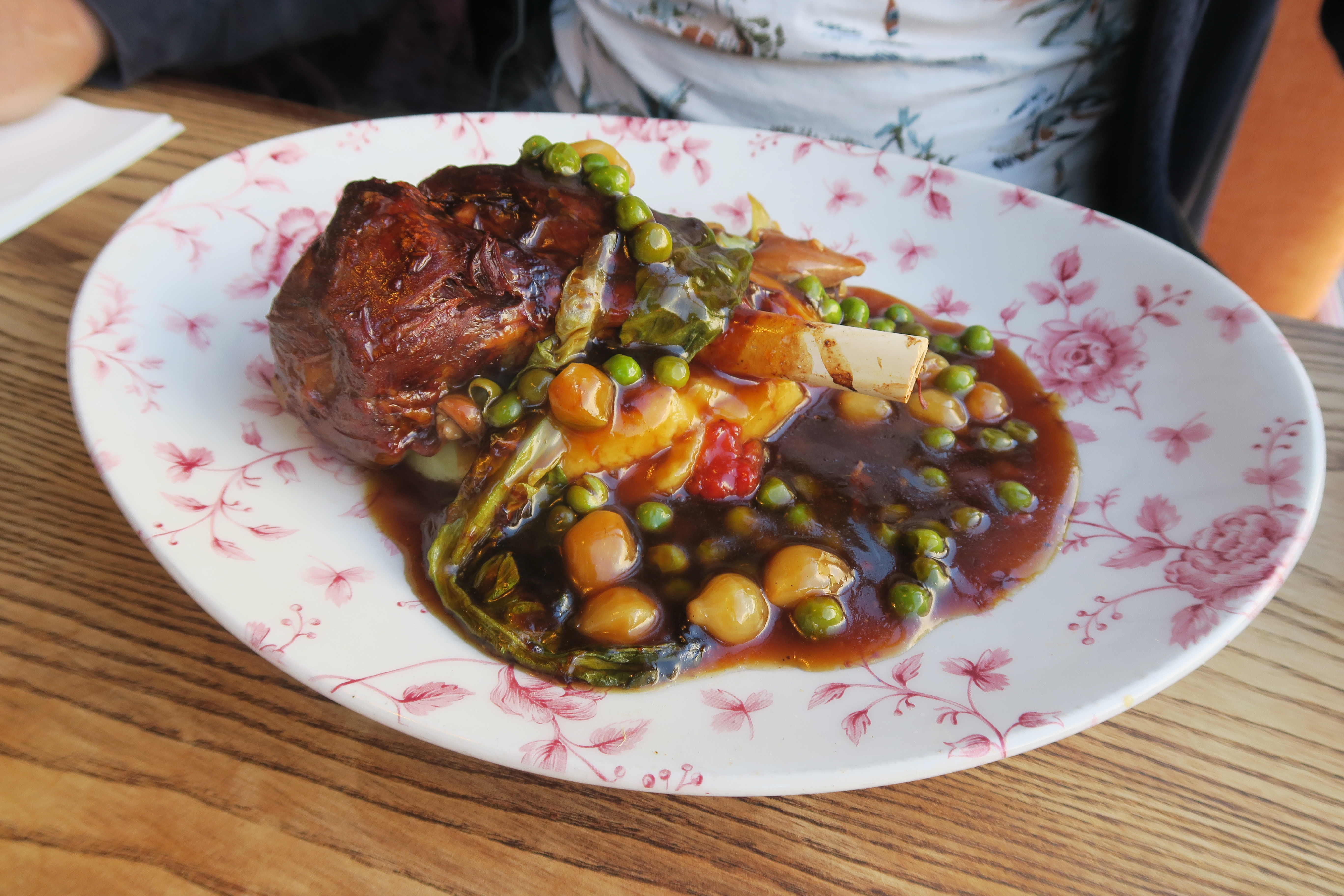 Braised Lamb Shank with greens in a deep plate