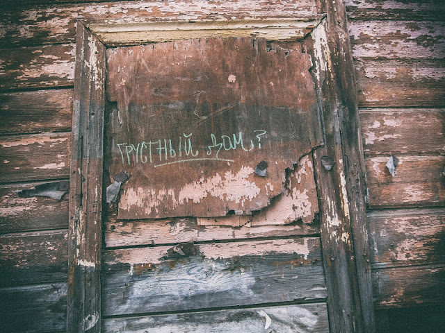 Надпись в заколоченном окне "Грустный дом?"