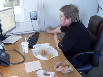 fat man eating burger. Eating at your desk is