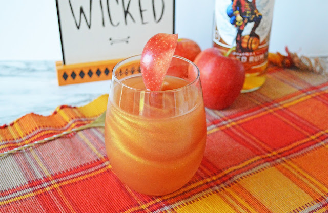drink in a clear glass with an apple slice garnish.