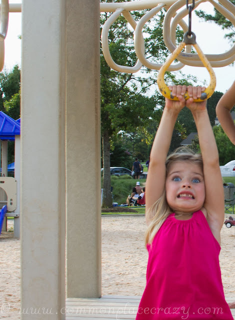 Little girl with big eyes frightened on the playground zip line