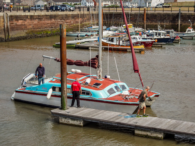 Photo of Phil (right) helping to moor up the cat when it returned to Maryport Marina