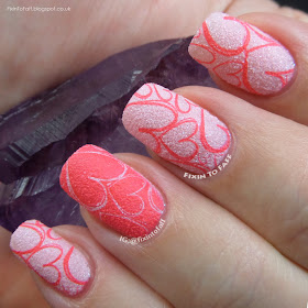 A textured pink and coral stamped Valentine's Day nail art of full-nail heart images.